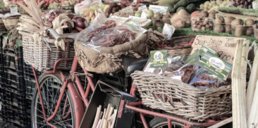 Cykel parkerad vid grönsaksstånd