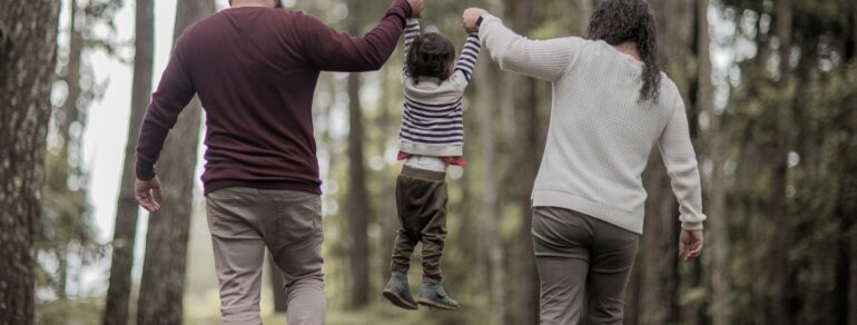 Familj på promenad i skogen