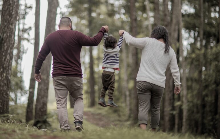 Familj på promenad i skogen