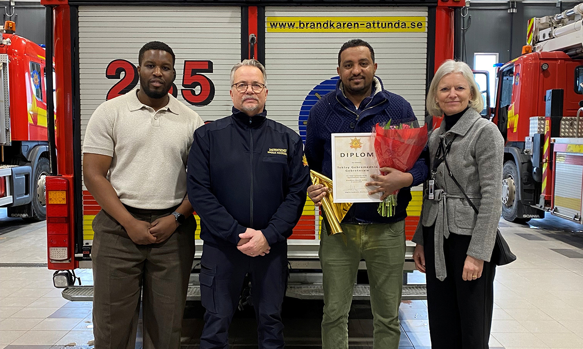 Personer som står bakom en brandbil