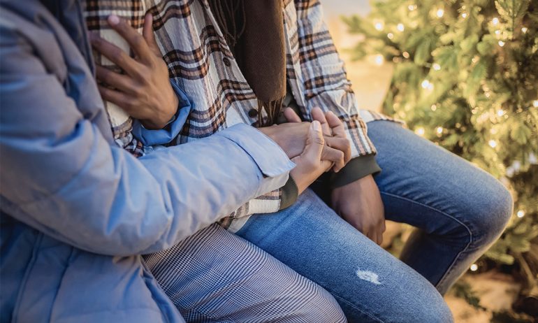 Personer som sitter och håller varandra i händerna