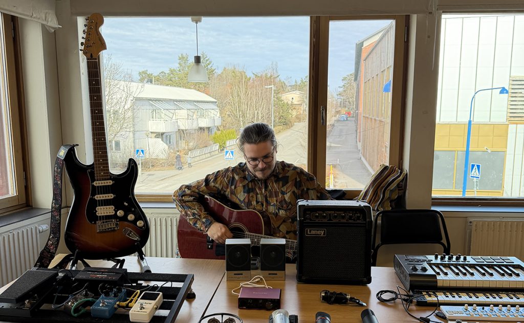 Man som spelar gitarr och säljer instrument