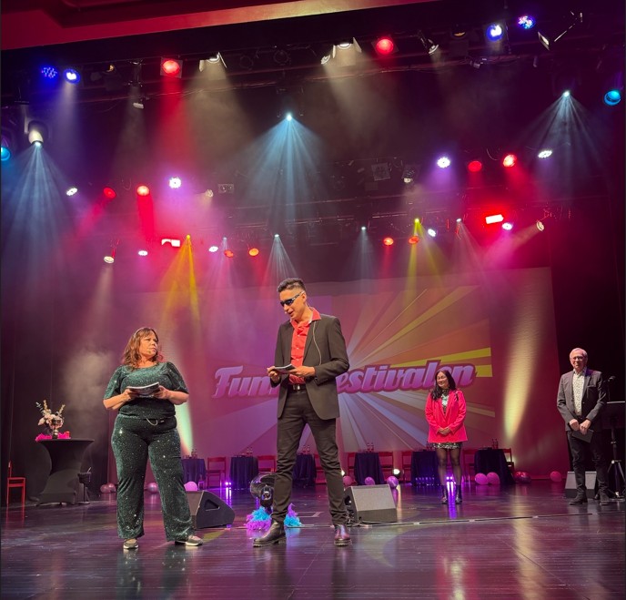 Två programledare pratar på scen