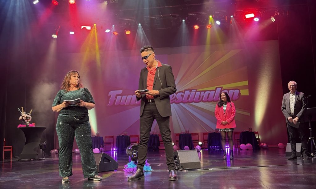 Två programledare pratar på scenen