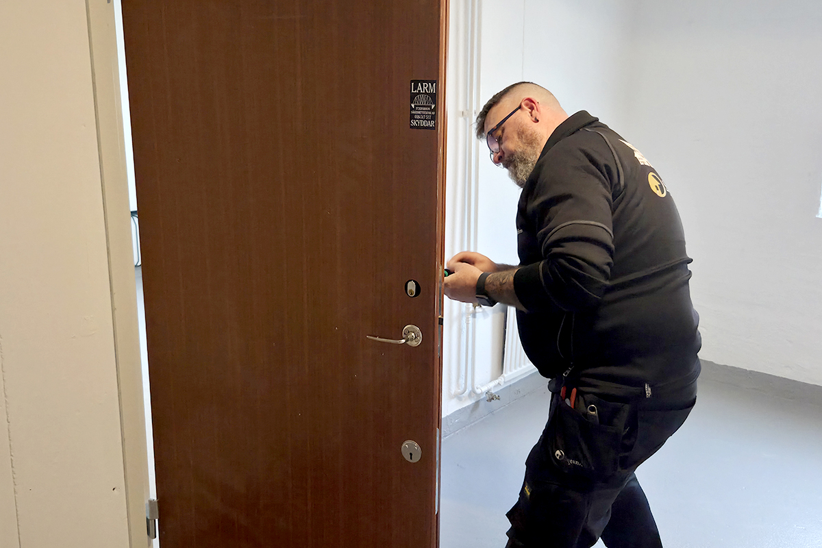 En person som fixar ett lås i en dörr.