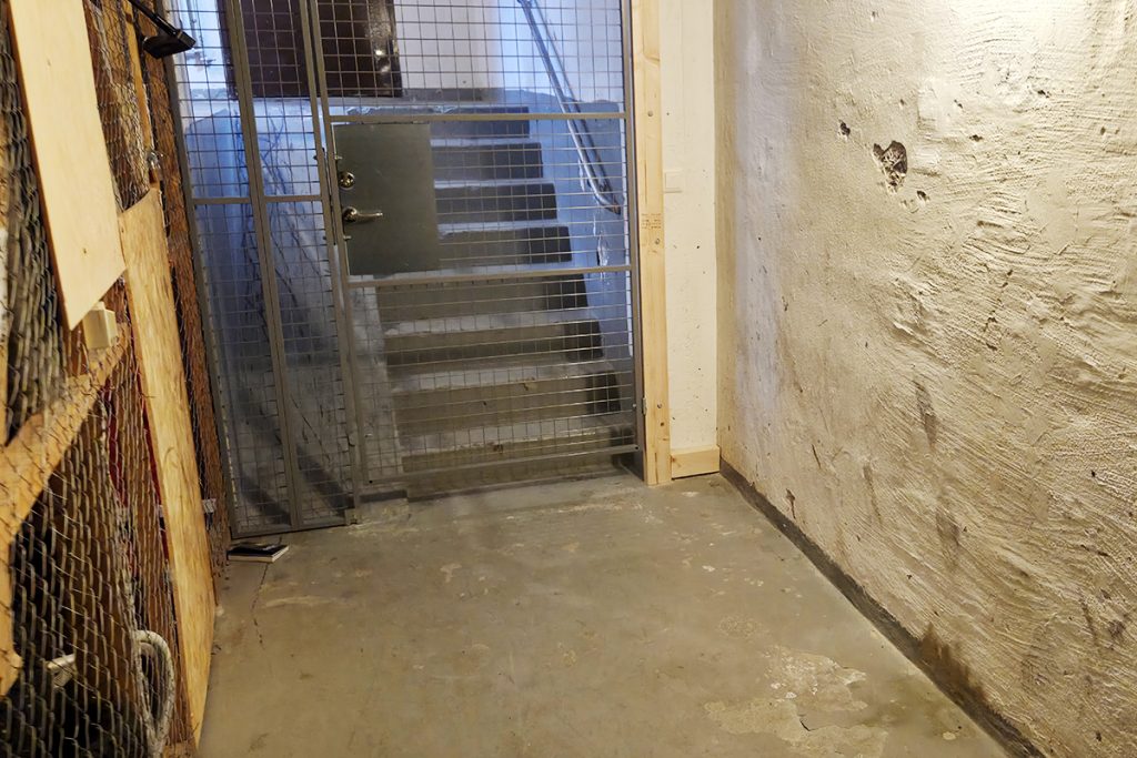 Vi går genom källargångarna till nästa trapphus.