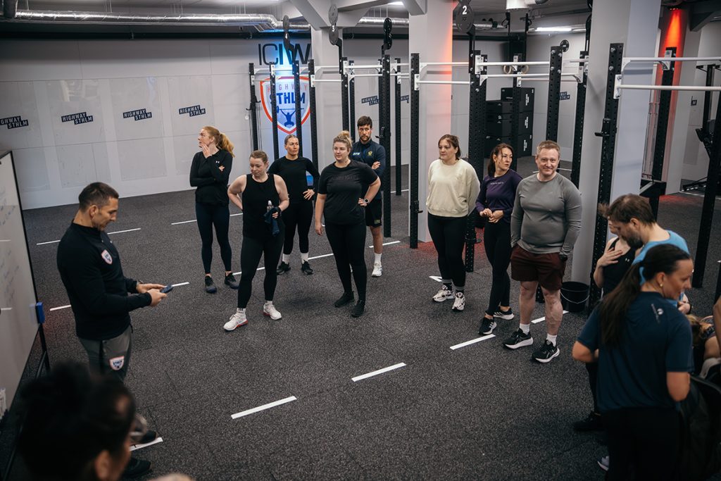 Deltagare som får instruktioner för ett Cross-fit pass