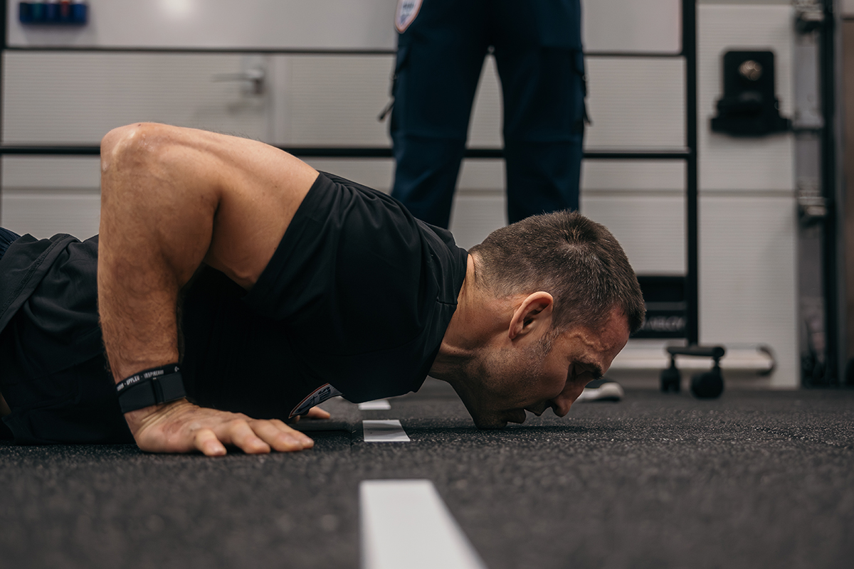 Coachen visar hur man gör armhävningar.