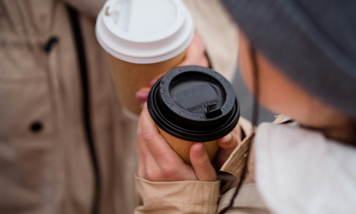 Två händer som håller i kaffemuggar