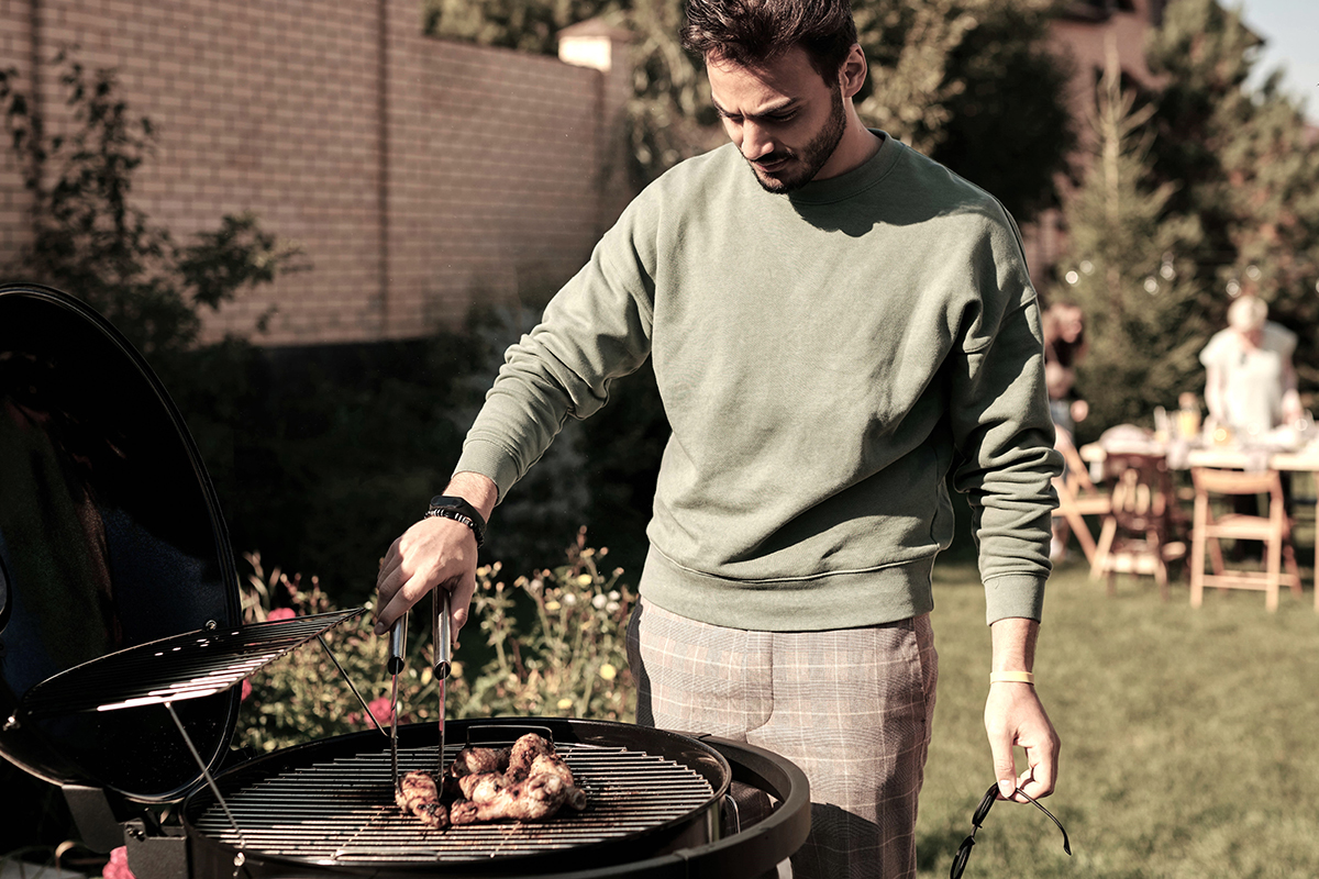 En kille som grillar utomhus