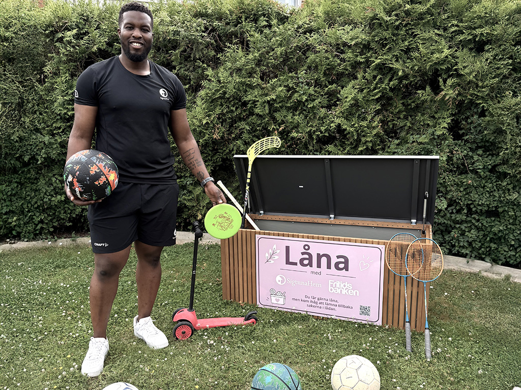 Man visar sportutrustning som går att låna från en utlåningslåda